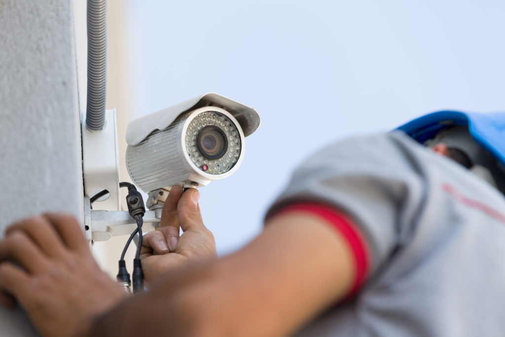Technician installing CCTV on someones home